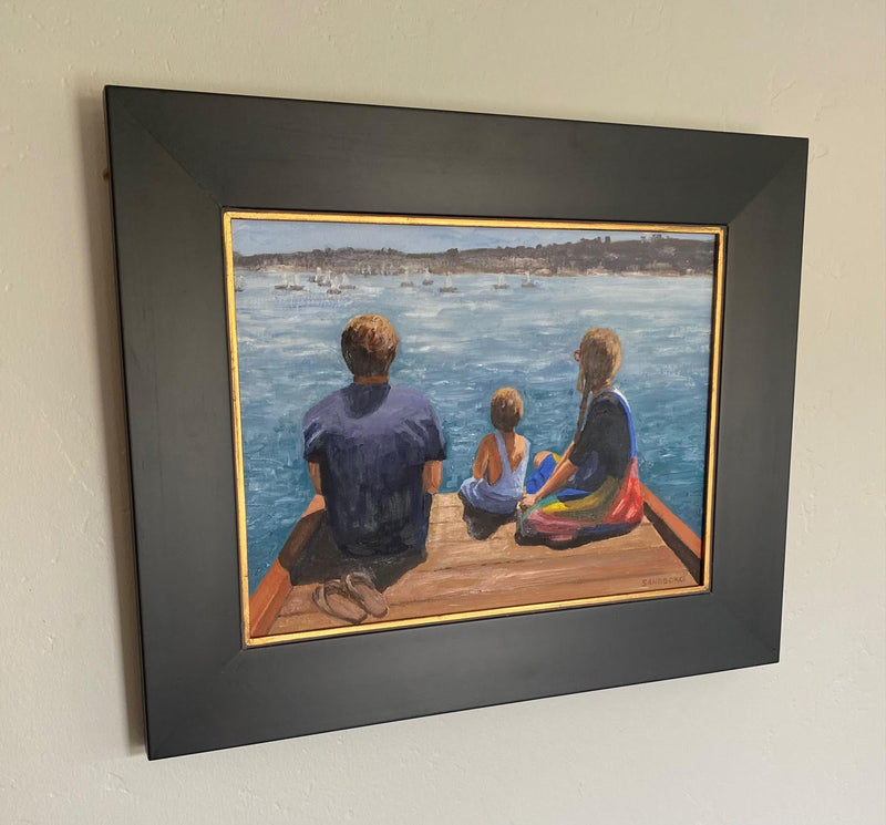 Image of an original oil painting of a family sitting on a dock watching a sailboat race by Steve Sandborg Art.  Shown in optional frame. 
